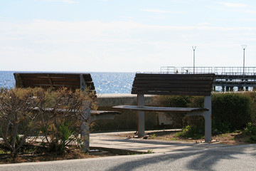 Fototapeta na wymiar Two empty benches by the sea