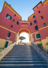 Fototapeta premium Rome (Italy) - The suggestive popular Garbatella quarter in Ostiense district, an agglomeration in Rococo style with gardens and the famous modern bridge named Settimia Spizzichino