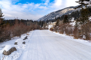 Snow and ice covered road in Banff National Park during Winter. This is Vermillion Lakes Road