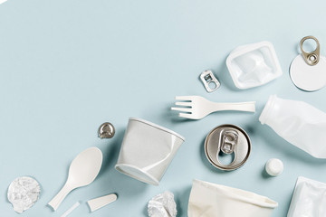 White single use plastic on  blue background.. Environmental, pollution concept. Flat lay, top view