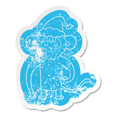 cartoon distressed sticker of a monkey scratching wearing santa hat
