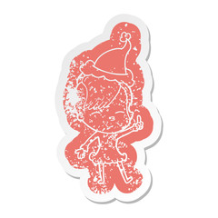 cartoon distressed sticker of a squinting girl wearing santa hat