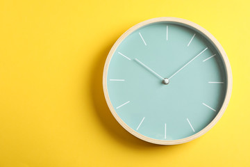 Big beautiful stylish clock on yellow background, space for text