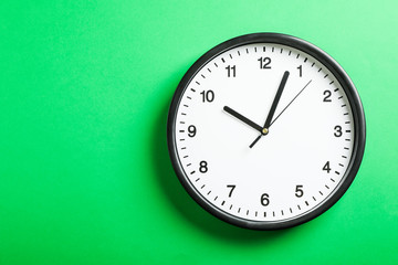 Big beautiful office clock on green background, space for text