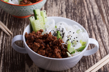 Asian style bowl with ground beef, rice noodles, cucumber, green onions and sesame seeds