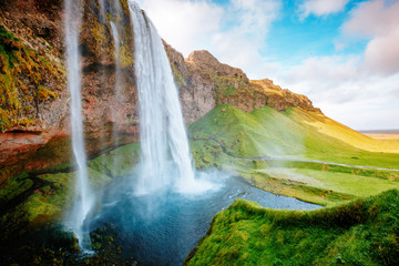 Perfect view of famous powerful Seljalandsfoss waterfall in sunlight. Location place Iceland,...