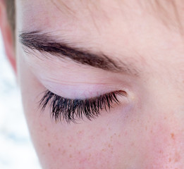 One eye of a teenager closed macro close-up