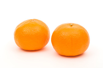 Two orange ripe tangerines in peel on white background, isolated