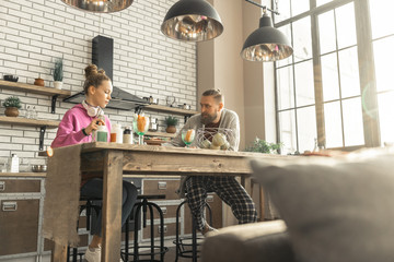 Father and daughter sitting in the kitchen and eating together