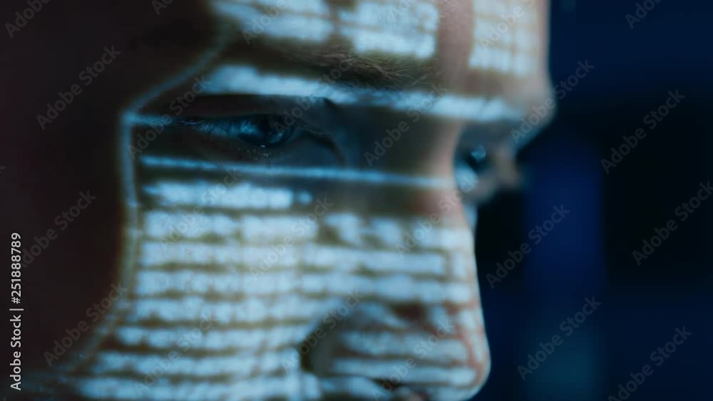 Leinwandbilder Portrait of Software Developer / Hacker Working on Personal Computer, Projected Moving Code Numbers and Characters Reflect on His Face. Dark Room Full of Electronics. Hacking and Programming Concept