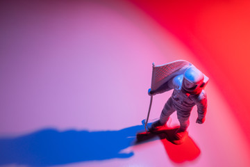 Lone Generic White Astronaut Figurine with American Flag in dramatic lighting - Powered by Adobe