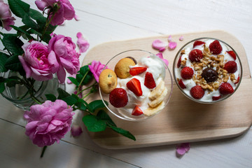white ice cream with strawberries and banana in a cup. background rose