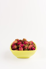 tea rose buds in a  drinking bowl  isolated on white background