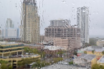 raining outside city scape buildings raindrops on glass window
