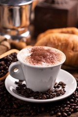  coffee cup close-up over dark roasted coffee beans