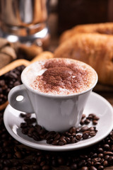  coffee cup close-up over dark roasted coffee beans