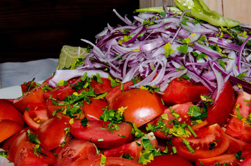 Tomato and Onion Salad. tomatoes cut into large slices on a plate and decorated with onions