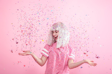 Funny Girl with silver hair gives a smile and emotion on pink background. Young woman or teen girl...