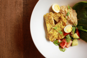 Chicken curry with salad in the plate, top view