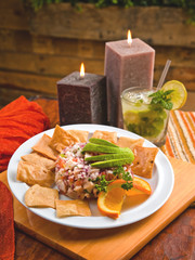 Fish ceviche with avocado, tortilla chips and a mojito