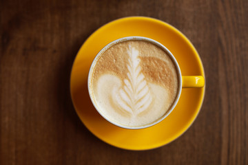 Latte in a yellow cup, flat lay
