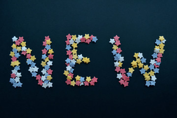 The word New in red white yellow and blue sugar stars, for business, advertising, commerce, sales