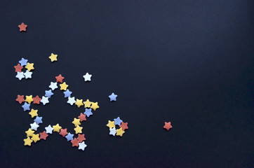 Star folded from multicolored sugar pastry stars on a blue background with copyspace