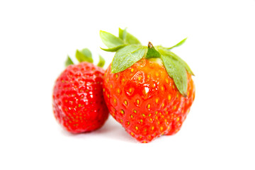 Several red strawberries with leaves on a white background