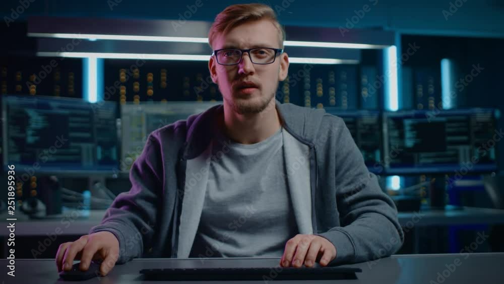 Fototapete Portrait of Software Developer / Hacker Wearing Glasses Sitting at His Desk and Working on Computer in Digital Identity Cyber Security Data Center. Hacking or Programming. POV Camera Shot