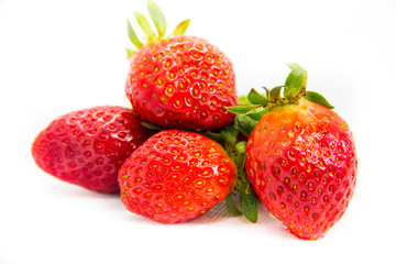 Several red strawberries with leaves on a white background