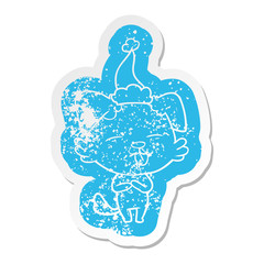cartoon distressed sticker of a dog sticking out tongue wearing santa hat