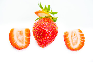 Whole and cut in half red strawberry and cut with leaves on white background