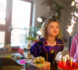 Girl Blowing Candles On Birthday Cake
