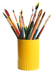 Holder with different paint brushes on white background