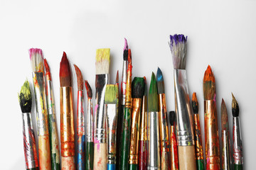 Obraz premium Different paint brushes on white background, top view