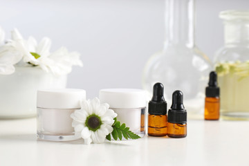 Skin care products, ingredients and laboratory glassware on table. Dermatology research