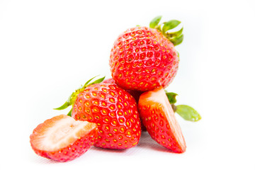 Whole and cut in half red strawberry and cut with leaves on white background