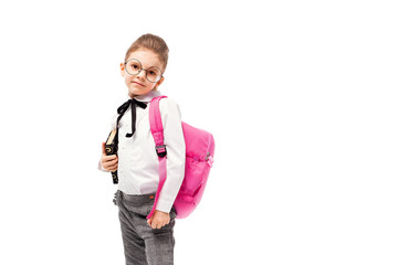 Back to school. Beautiful little girl dressed like a School girl - in white shirt and gray pants, rounded glasses, hold a book with school bag and posing like model. Isolated on white background.