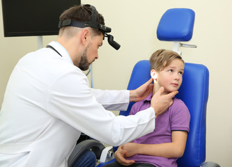 Obraz premium Male otolaryngologist examining little child in hospital