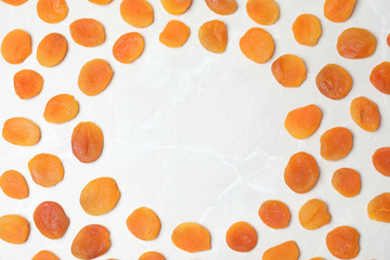 Frame made of apricots on light background, top view with space for text. Dried fruit as healthy food