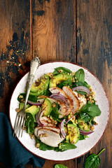 Spinach salad with grilled chicken fillet, avocado and walnuts.Top view with copy space.