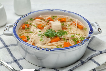 Dish with fresh homemade chicken soup served on table, closeup