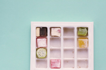 Traditional turkish delight  on blue background.  Arabic traditional dessert rahat lukum in a box. 