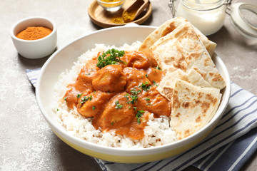 Delicious butter chicken with rice in plate on table
