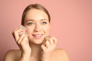 Young woman with ice cubes on color background, space for text. Skin care