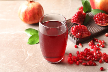 Composition with glass of fresh pomegranate juice on table