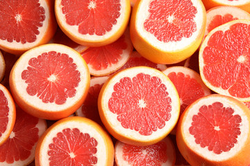 Fototapeta na wymiar Many sliced fresh grapefruits as background, top view