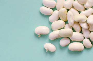 Fototapeta na wymiar Organic fresh white kidney beans on blue background. macro