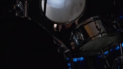 Girl drummer banging on a drum kit on stage.
