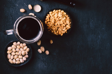 bar table. dark beer and snacks set. restaurant, pub, food concept. delicious drink and salty peanuts. oktoberfest atmosphere, craft brewery background